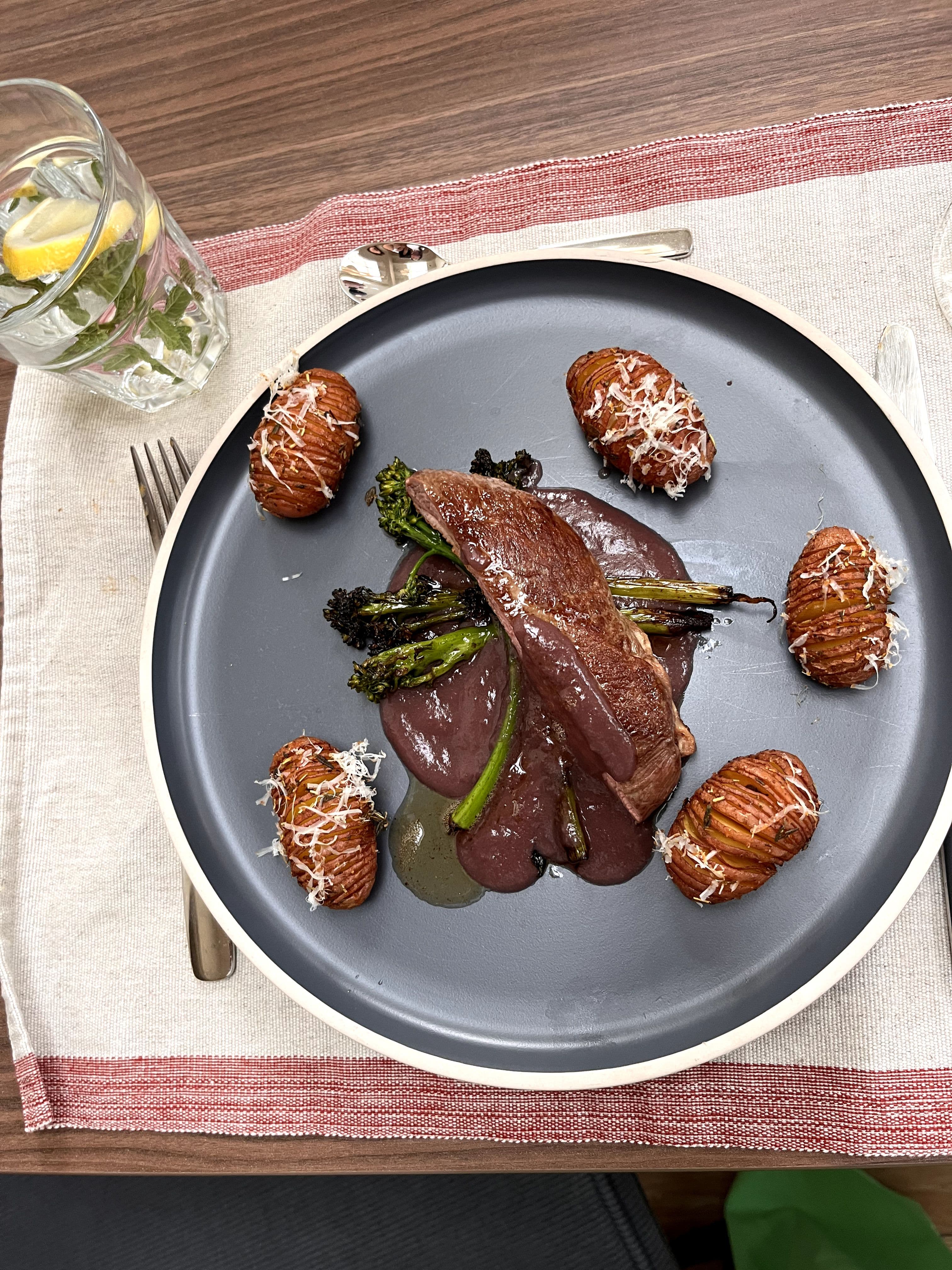 Eendenborstfilet in rodewijnsaus met bimi en roseval hasselback aardappels met Parmezaanse kaas
